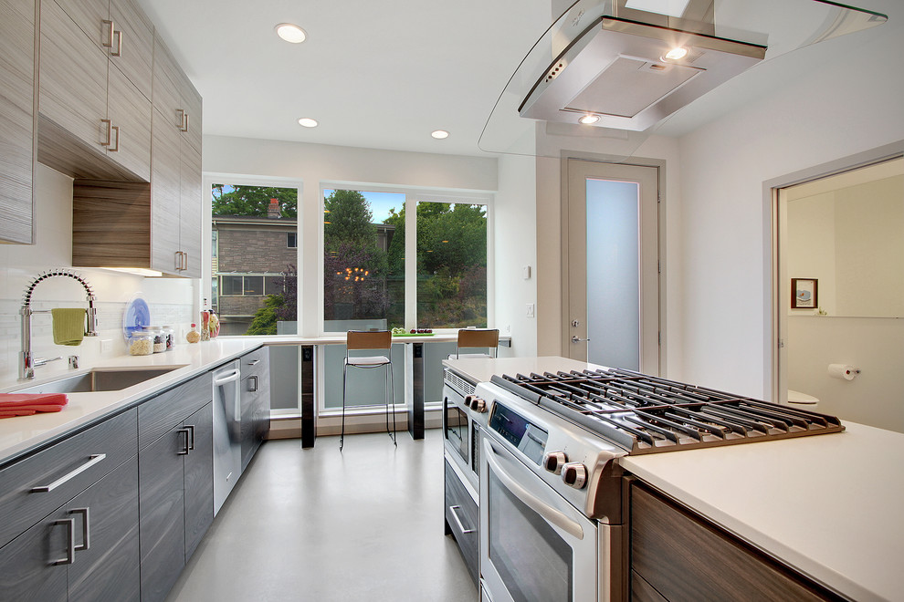 На фото: параллельная кухня в современном стиле с обеденным столом, врезной мойкой, плоскими фасадами, серыми фасадами, белым фартуком, белой техникой и фартуком из каменной плитки