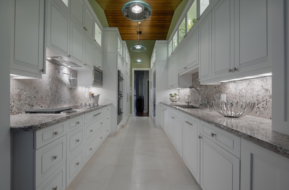 Diseño de cocina contemporánea, cerrada, con salpicadero de losas de piedra y electrodomésticos de acero inoxidable