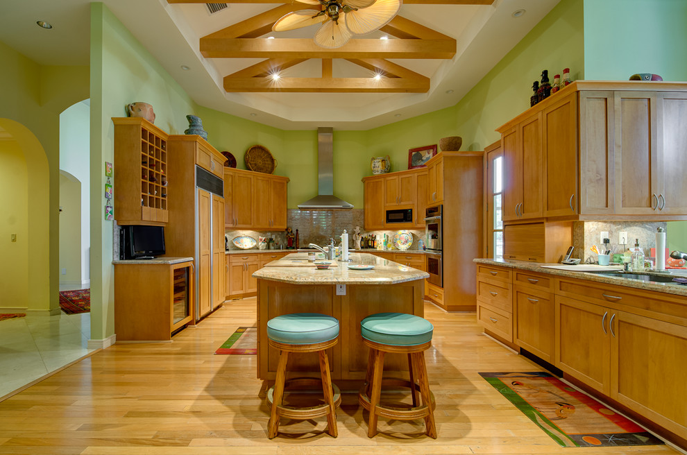 Kitchen - tropical u-shaped kitchen idea in Miami with an undermount sink, shaker cabinets, medium tone wood cabinets, beige backsplash and paneled appliances