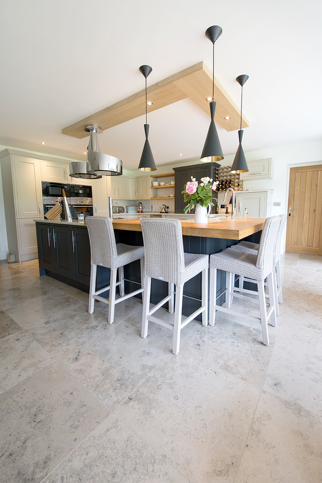Example of a mid-sized trendy limestone floor eat-in kitchen design in Other with an island