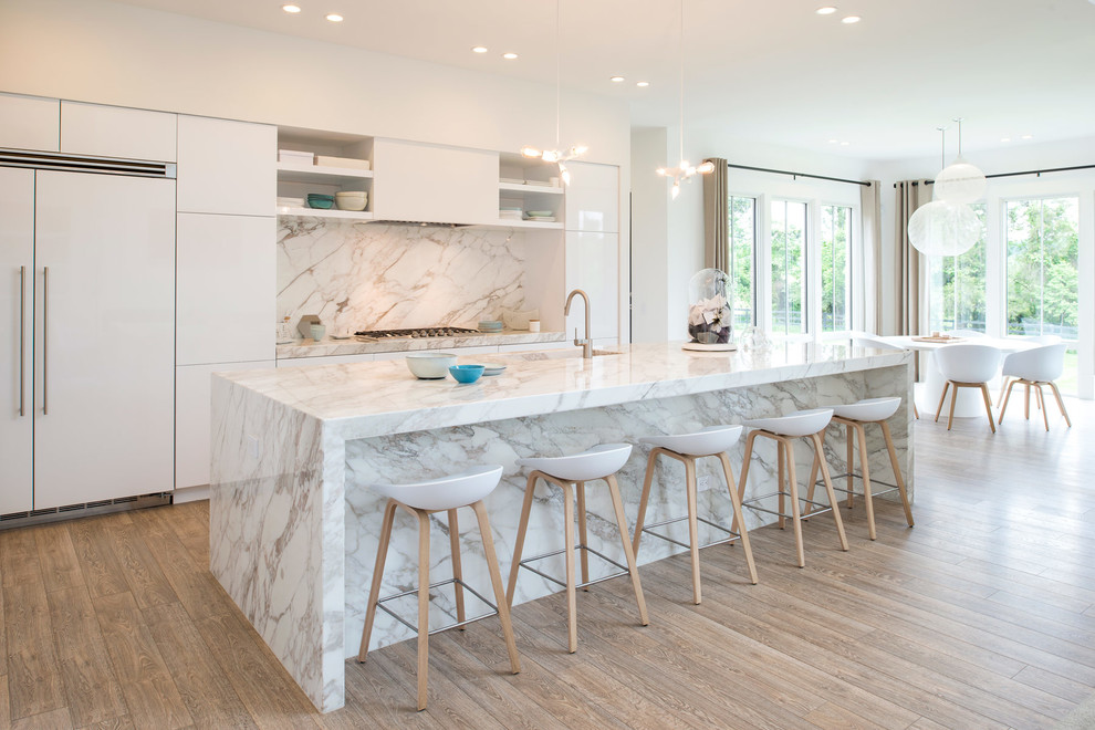 Large danish galley light wood floor open concept kitchen photo in DC Metro with an integrated sink, flat-panel cabinets, white cabinets, white backsplash, paneled appliances, an island and marble backsplash