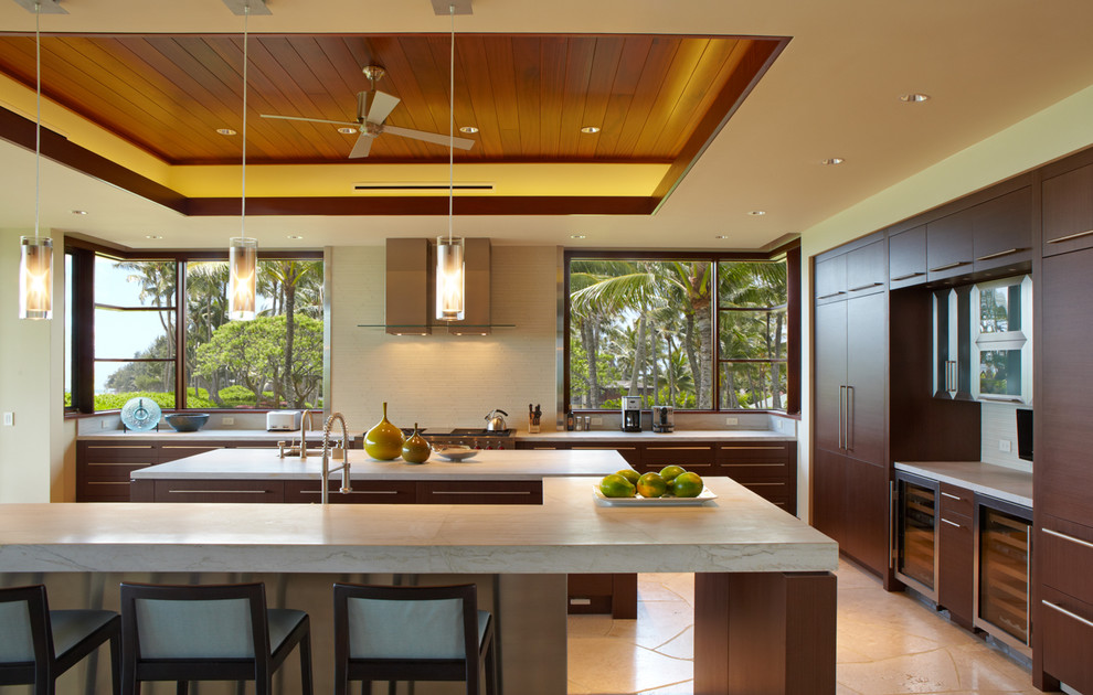 Große Küche in U-Form mit dunklen Holzschränken und Schieferboden in Hawaii