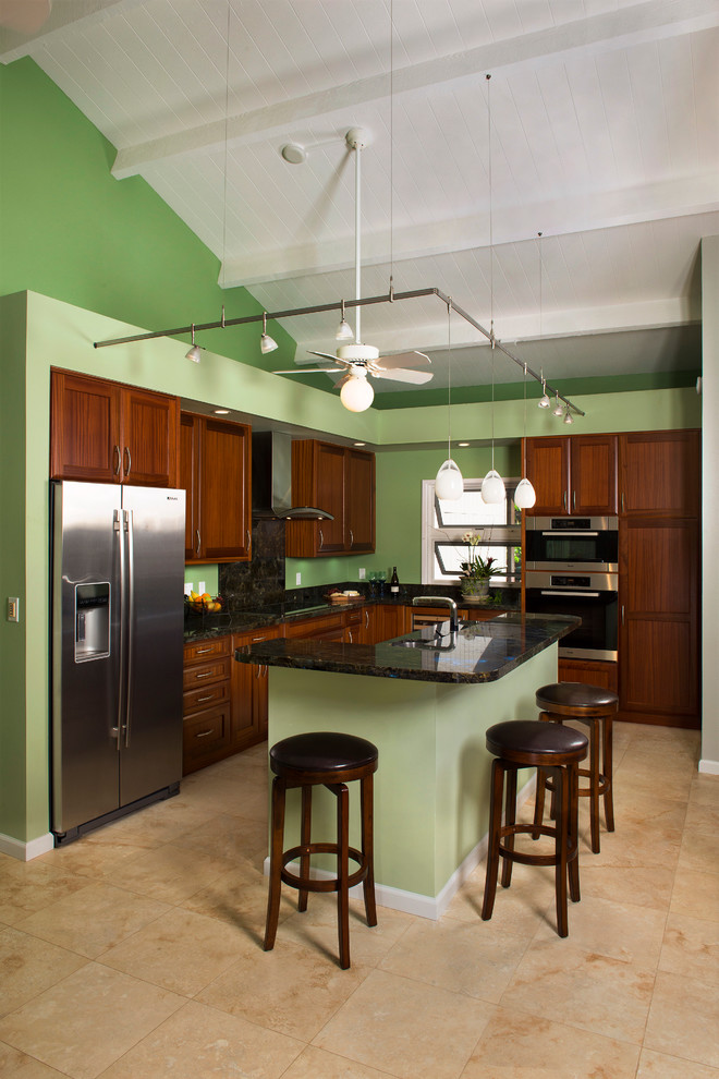 Idéer för att renovera ett mellanstort tropiskt kök, med en undermonterad diskho, luckor med infälld panel, skåp i mellenmörkt trä, granitbänkskiva, flerfärgad stänkskydd, stänkskydd i sten, rostfria vitvaror, travertin golv och en köksö