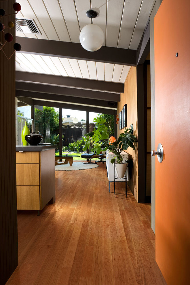 Idée de décoration pour une cuisine ouverte minimaliste en U et bois brun de taille moyenne avec un placard à porte plane, un sol en bois brun et îlot.