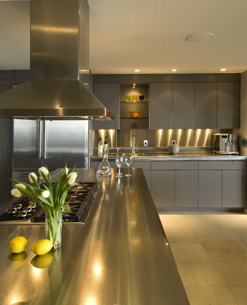Immagine di una grande cucina minimalista con lavello integrato, ante lisce, ante grigie, top in acciaio inossidabile, paraspruzzi a effetto metallico, elettrodomestici in acciaio inossidabile, pavimento beige e top grigio