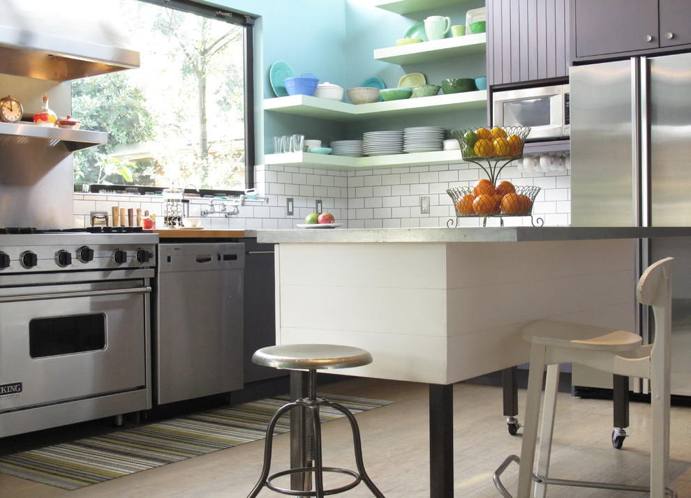 Exempel på ett stort modernt kök, med vitt stänkskydd, stänkskydd i tunnelbanekakel, rostfria vitvaror, en köksö, släta luckor, en undermonterad diskho, ljust trägolv, lila skåp och marmorbänkskiva