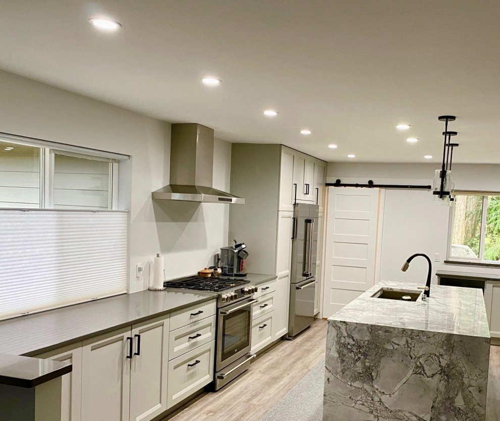 Idéer för att renovera ett mellanstort funkis grå linjärt grått kök och matrum, med en undermonterad diskho, luckor med infälld panel, grå skåp, bänkskiva i kvarts, rostfria vitvaror, vinylgolv, en köksö och grått golv