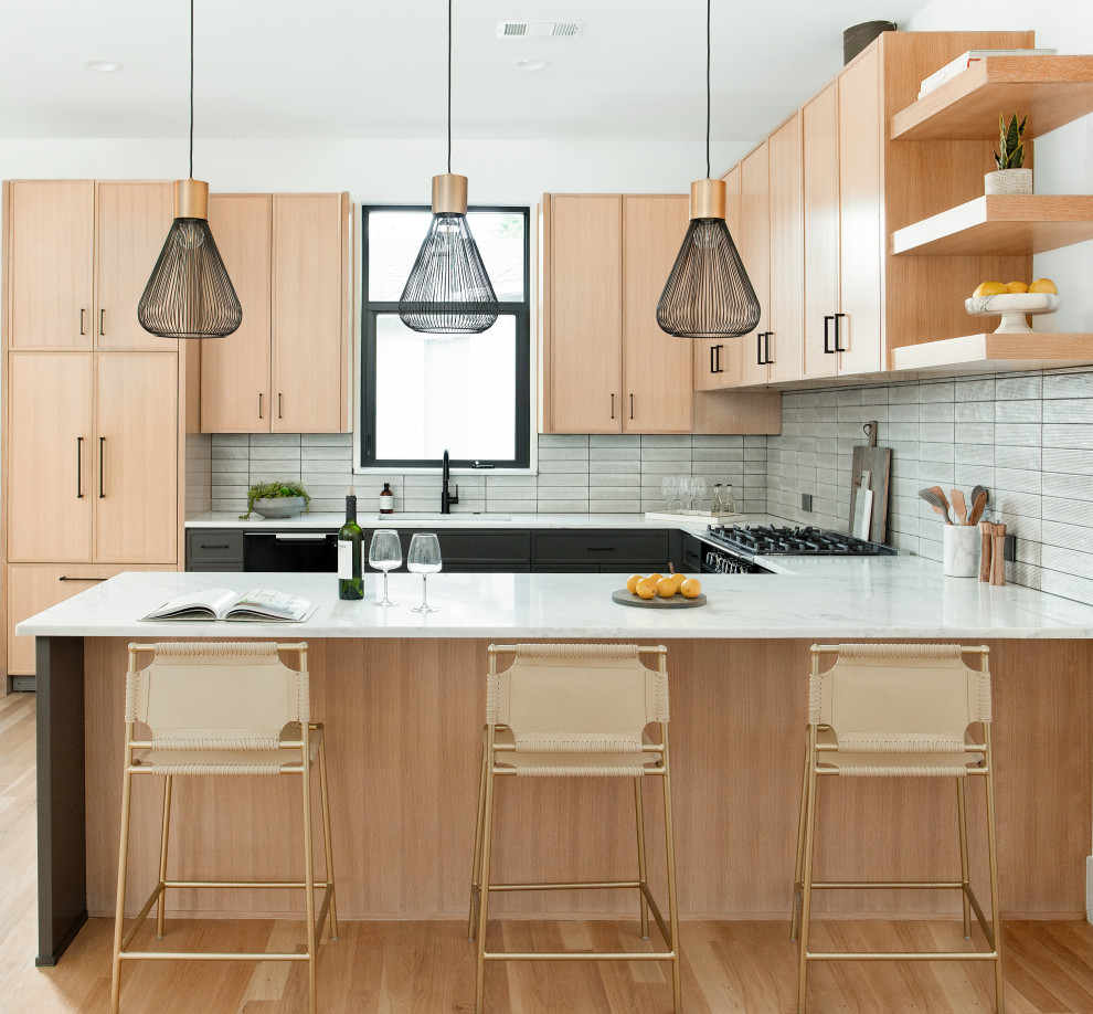 Immagine di una cucina ad U nordica con ante lisce, ante in legno chiaro, paraspruzzi bianco, parquet chiaro, penisola, pavimento beige e top bianco