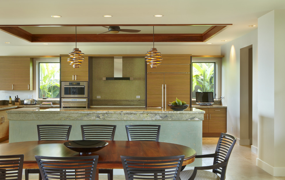 ハワイにあるトロピカルスタイルのおしゃれなキッチン (フラットパネル扉のキャビネット、中間色木目調キャビネット、シングルシンク、御影石カウンター、緑のキッチンパネル、ガラスタイルのキッチンパネル、シルバーの調理設備) の写真