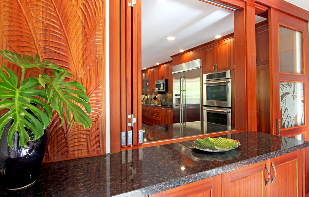 Küche mit Schrankfronten im Shaker-Stil, hellbraunen Holzschränken und Granit-Arbeitsplatte in Hawaii