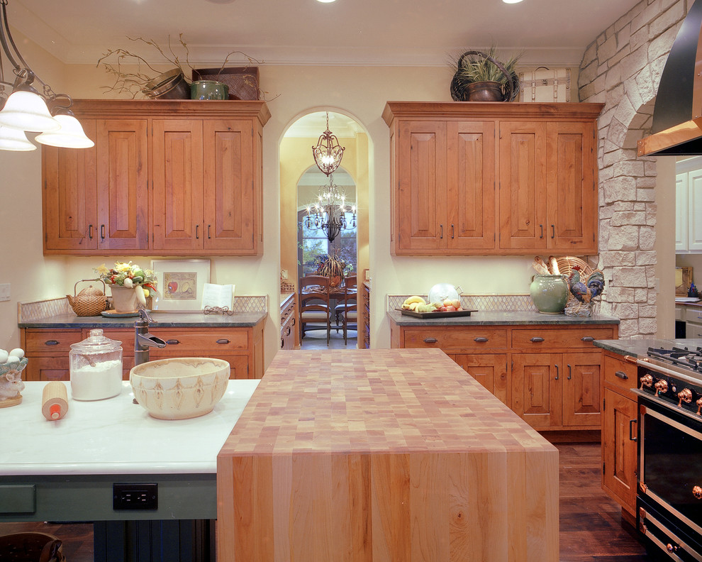 Bild på ett avskilt, stort rustikt u-kök, med en enkel diskho, luckor med upphöjd panel, skåp i mellenmörkt trä, bänkskiva i zink, vitt stänkskydd, stänkskydd i stenkakel, rostfria vitvaror, mörkt trägolv och en köksö