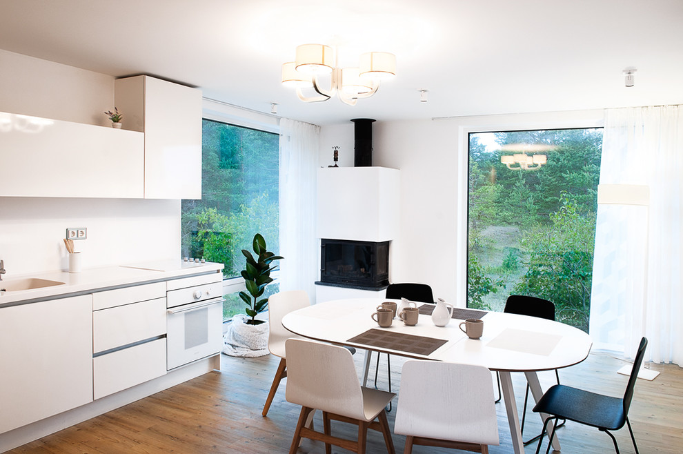 Modelo de cocina comedor minimalista con fregadero integrado, armarios con paneles lisos, puertas de armario blancas y electrodomésticos blancos