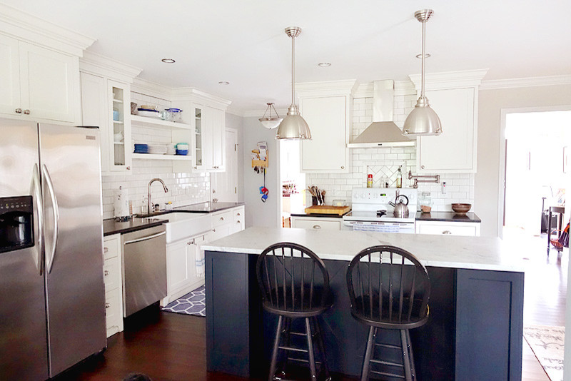 Eat-in kitchen - mid-sized traditional l-shaped medium tone wood floor eat-in kitchen idea in Other with a farmhouse sink, shaker cabinets, white cabinets, marble countertops, white backsplash, subway tile backsplash, stainless steel appliances and an island