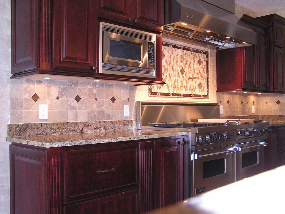 Foto di una cucina stile rurale con ante rosse, top in granito, paraspruzzi marrone, paraspruzzi in travertino, elettrodomestici in acciaio inossidabile, pavimento in gres porcellanato, pavimento marrone e top marrone