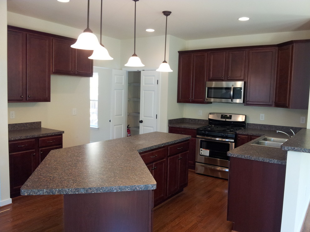 Large classic u-shaped kitchen/diner in Richmond with a submerged sink, recessed-panel cabinets, dark wood cabinets, granite worktops, stainless steel appliances, dark hardwood flooring and a breakfast bar.