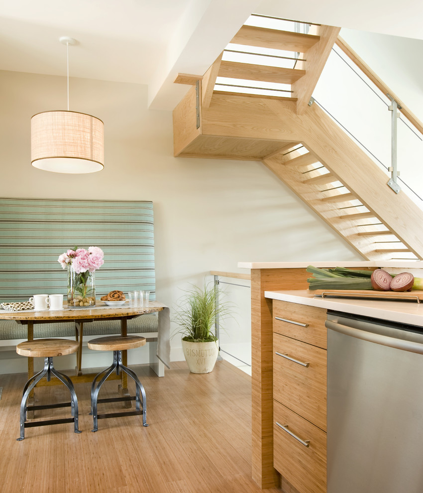 Foto på ett funkis kök och matrum, med skåp i ljust trä och rostfria vitvaror
