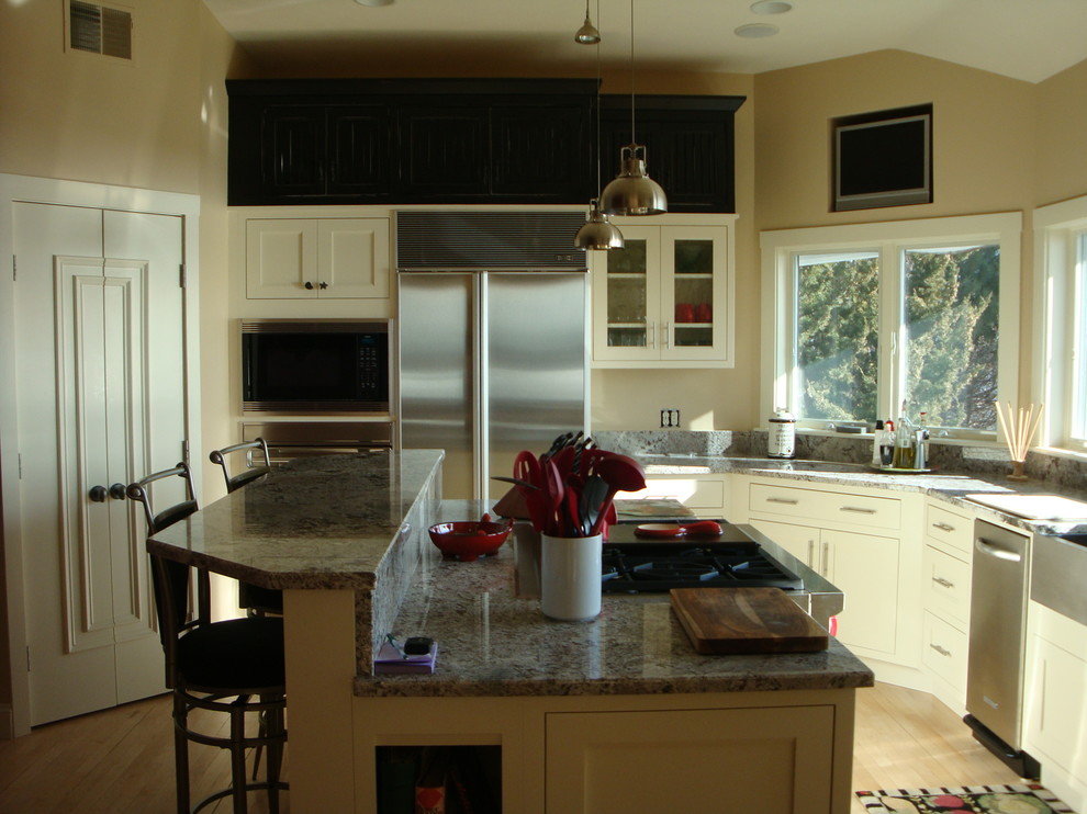 Imagen de cocinas en L tradicional renovada con fregadero sobremueble, puertas de armario blancas, electrodomésticos de acero inoxidable, una isla y encimeras grises
