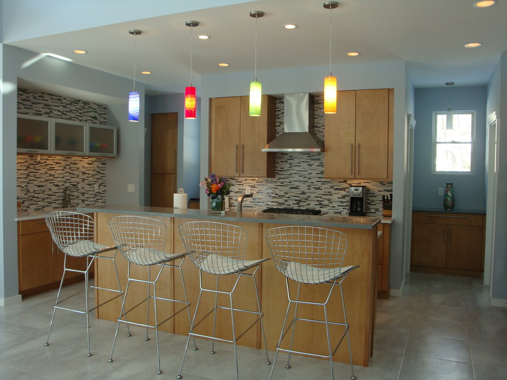 Foto di una cucina moderna chiusa e di medie dimensioni con ante lisce, ante in legno chiaro, paraspruzzi grigio, paraspruzzi con piastrelle a listelli, elettrodomestici in acciaio inossidabile, pavimento grigio e top grigio