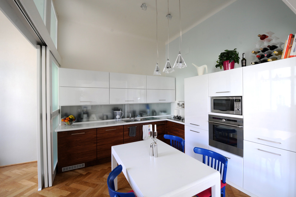 Foto di una cucina a L moderna con ante lisce, ante bianche e elettrodomestici in acciaio inossidabile