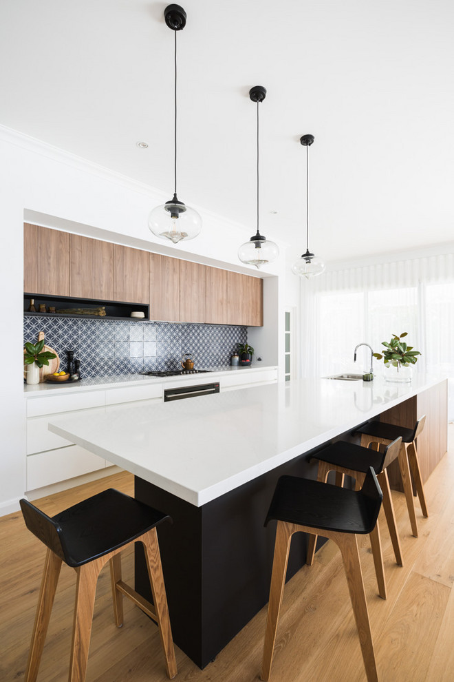 Moderne Küche mit Unterbauwaschbecken, flächenbündigen Schrankfronten, hellen Holzschränken, bunter Rückwand, hellem Holzboden, Kücheninsel und weißer Arbeitsplatte in Perth