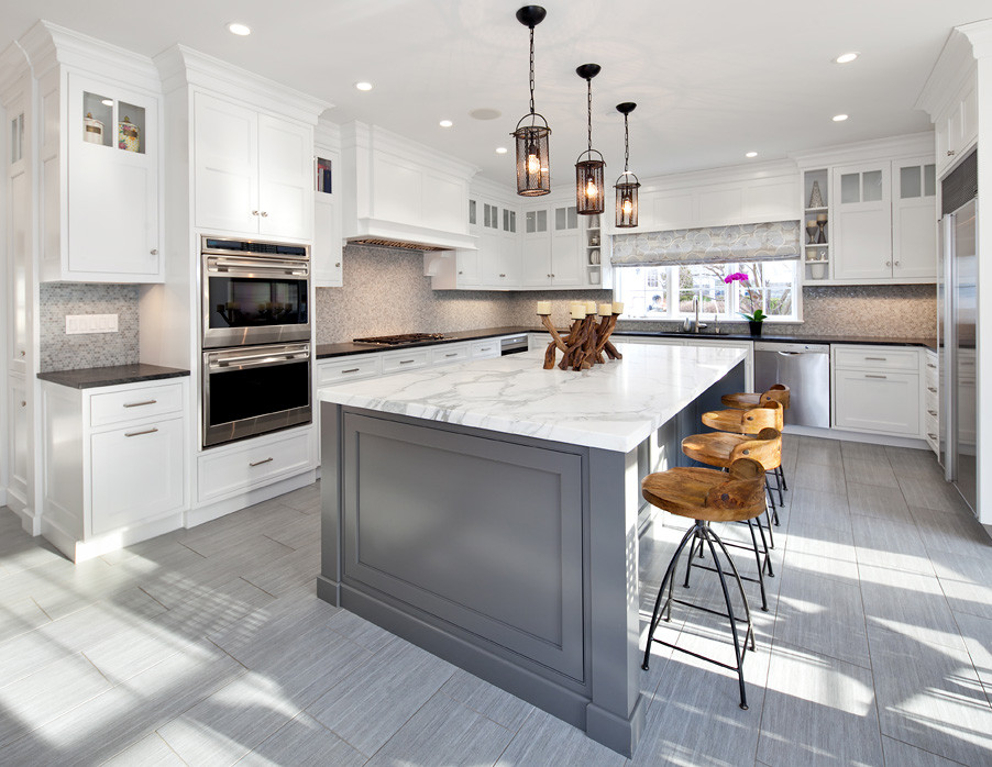 Example of a mid-sized transitional u-shaped porcelain tile and gray floor open concept kitchen design in New York with an undermount sink, recessed-panel cabinets, white cabinets, marble countertops, multicolored backsplash, mosaic tile backsplash, stainless steel appliances and an island