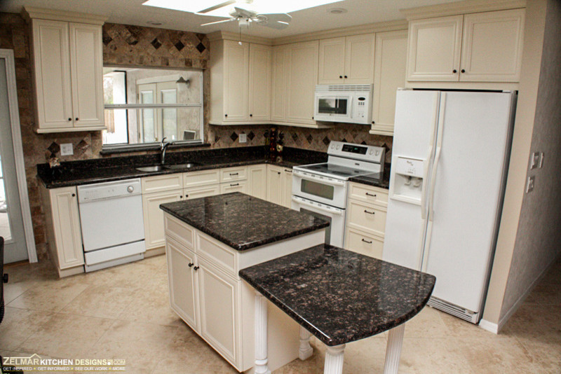 Inspiration for a large timeless u-shaped porcelain tile eat-in kitchen remodel in Orlando with an undermount sink, recessed-panel cabinets, white cabinets, granite countertops, multicolored backsplash, porcelain backsplash and an island
