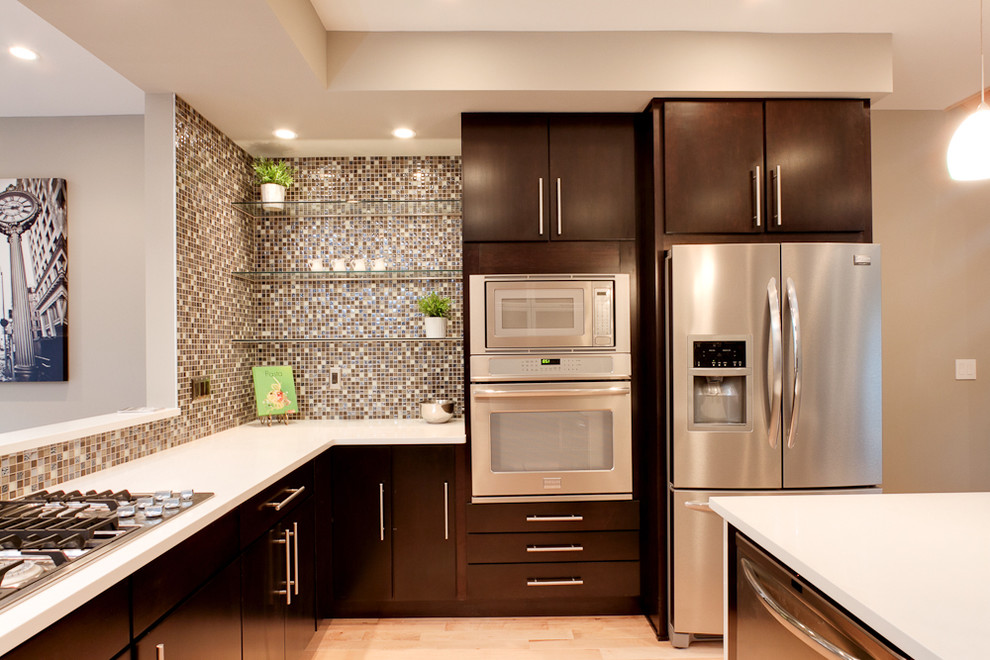 Imagen de cocina contemporánea con salpicadero con mosaicos de azulejos, electrodomésticos de acero inoxidable, salpicadero marrón, armarios con paneles lisos y puertas de armario de madera en tonos medios