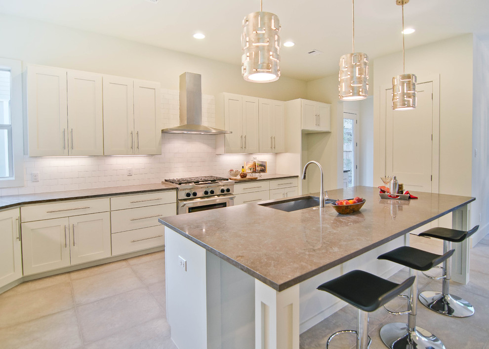 Klassische Küche mit Rückwand aus Metrofliesen, Kalkstein-Arbeitsplatte, Waschbecken, weißen Schränken und Küchenrückwand in Weiß in Austin