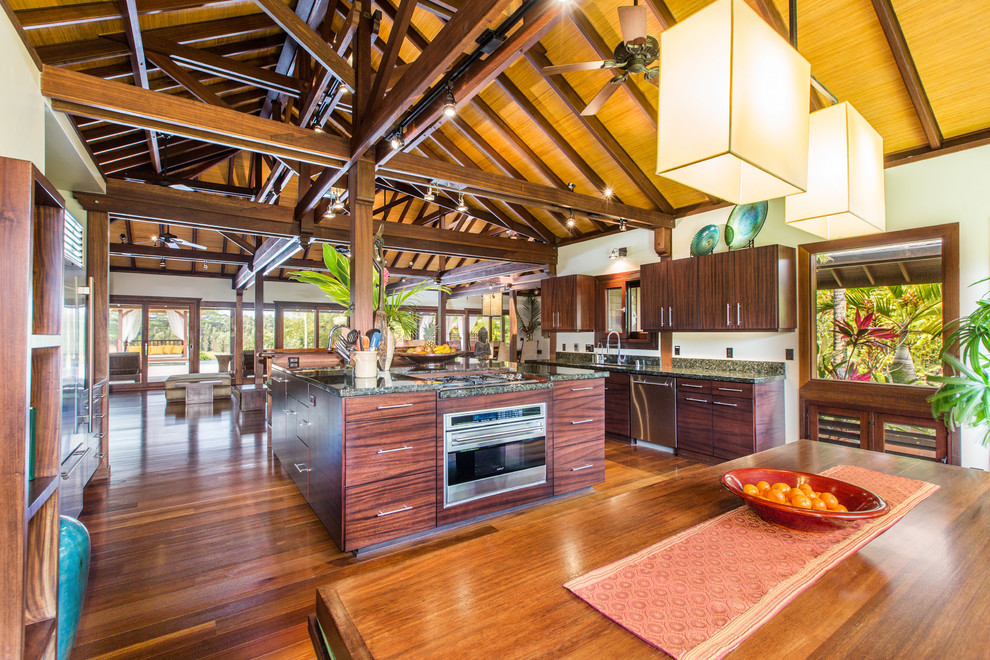 Enclosed kitchen - huge tropical u-shaped dark wood floor and brown floor enclosed kitchen idea in Hawaii with flat-panel cabinets, stainless steel appliances and an island