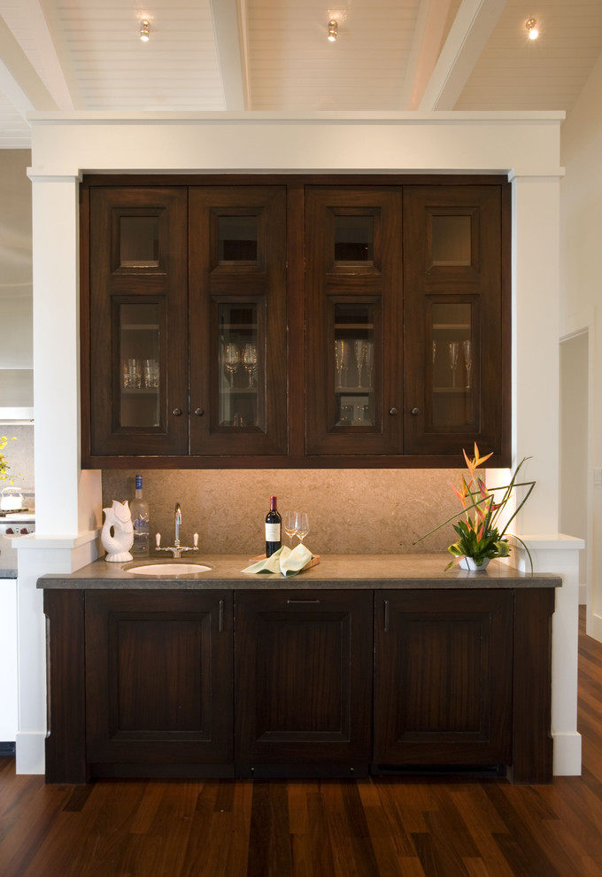 Contemporary kitchen in San Francisco with a submerged sink, glass-front cabinets and dark wood cabinets.