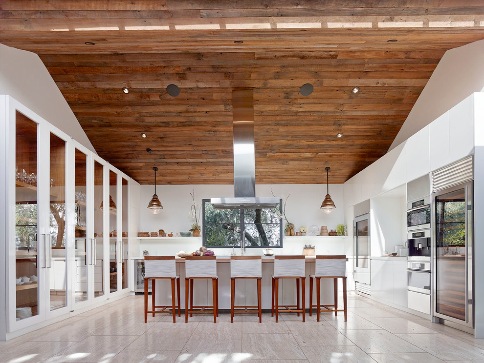 This is an example of a contemporary u-shaped kitchen in Los Angeles with glass-front cabinets, white cabinets and an island.