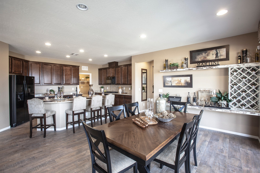Mittelgroße Shabby-Look Wohnküche in U-Form mit braunem Holzboden, Unterbauwaschbecken, dunklen Holzschränken, Granit-Arbeitsplatte, schwarzen Elektrogeräten und Kücheninsel in Las Vegas