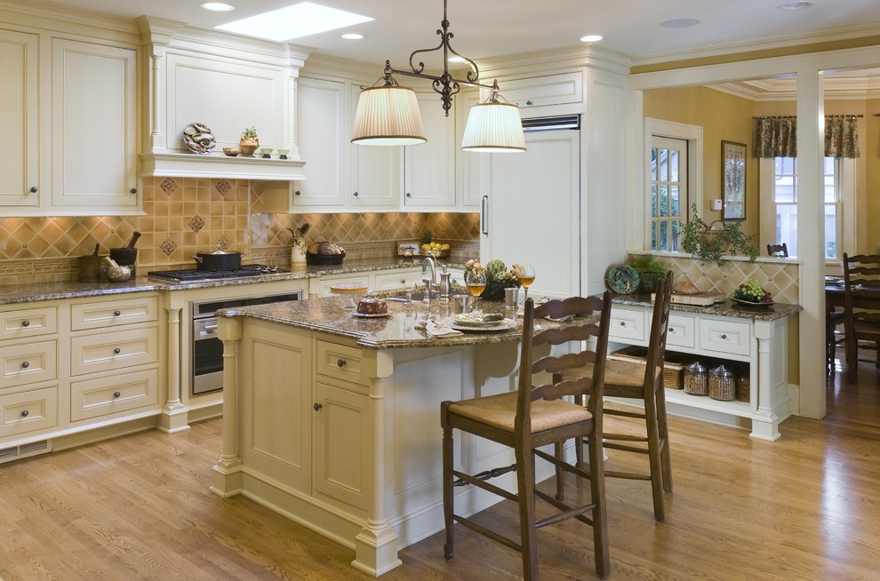 This is an example of a traditional kitchen in New York with recessed-panel cabinets, beige cabinets, beige splashback and integrated appliances.