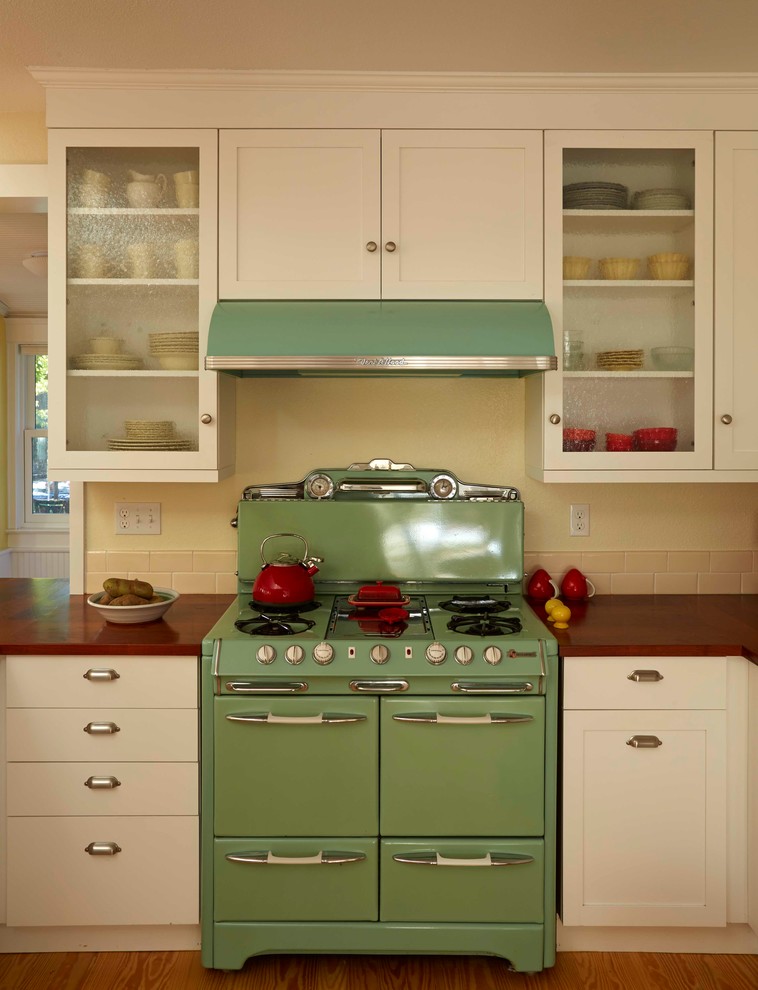 Exempel på ett mellanstort klassiskt kök, med en rustik diskho, skåp i shakerstil, vita skåp, träbänkskiva, beige stänkskydd, stänkskydd i keramik, färgglada vitvaror, mellanmörkt trägolv och en köksö