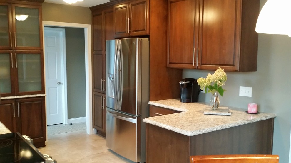 Example of a mid-sized transitional ceramic tile and beige floor eat-in kitchen design in Other with raised-panel cabinets, stainless steel appliances, an undermount sink, medium tone wood cabinets, granite countertops and no island