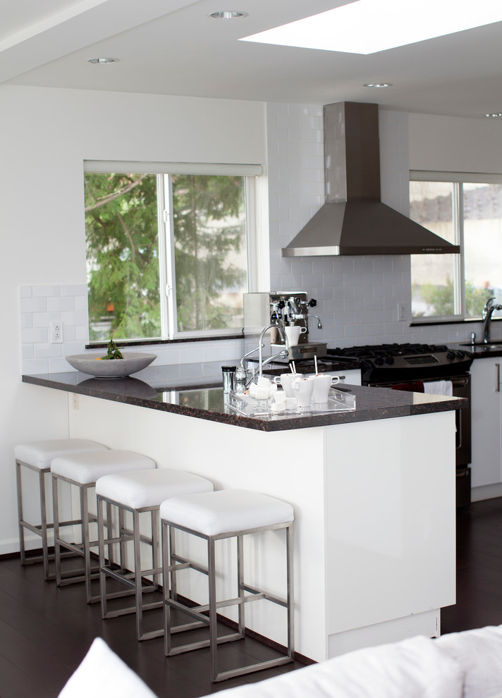 Immagine di una cucina ad ambiente unico classica con ante lisce, ante bianche, parquet scuro e penisola
