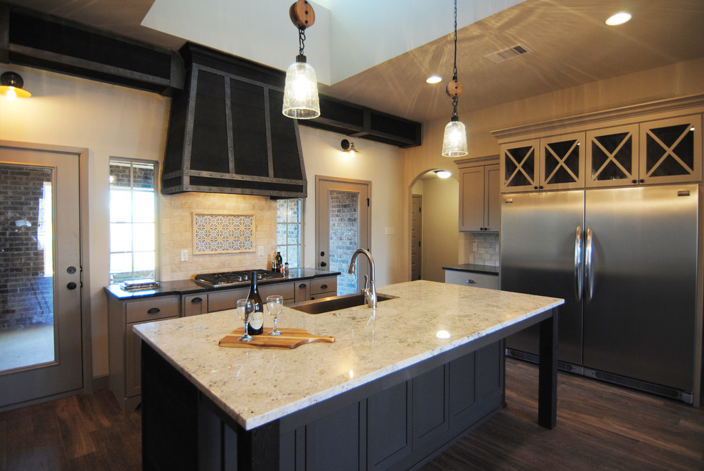 Foto på ett mellanstort eklektiskt kök, med en rustik diskho, luckor med infälld panel, grå skåp, granitbänkskiva, beige stänkskydd, stänkskydd i stenkakel, rostfria vitvaror, vinylgolv och en köksö
