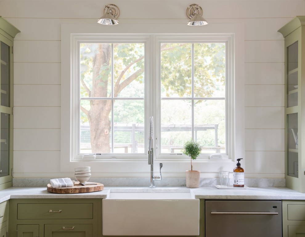 Bild på ett litet lantligt kök, med en rustik diskho, luckor med infälld panel, gröna skåp, marmorbänkskiva, vitt stänkskydd, rostfria vitvaror och ljust trägolv