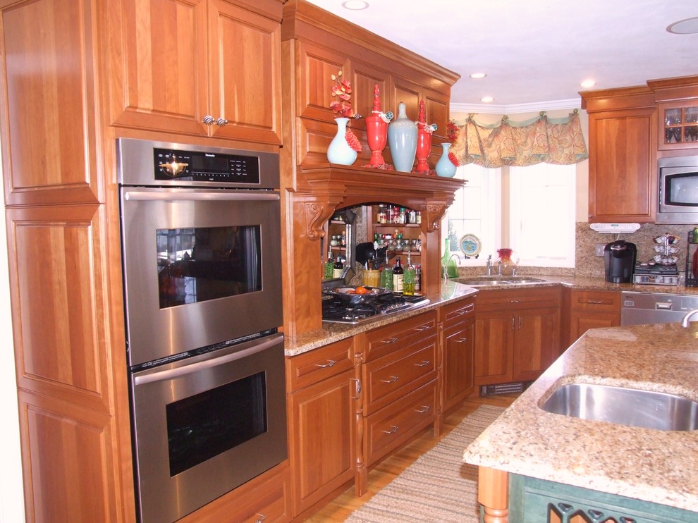 Esempio di una cucina abitabile chic con ante in legno scuro, top in granito, elettrodomestici in acciaio inossidabile e lavello da incasso