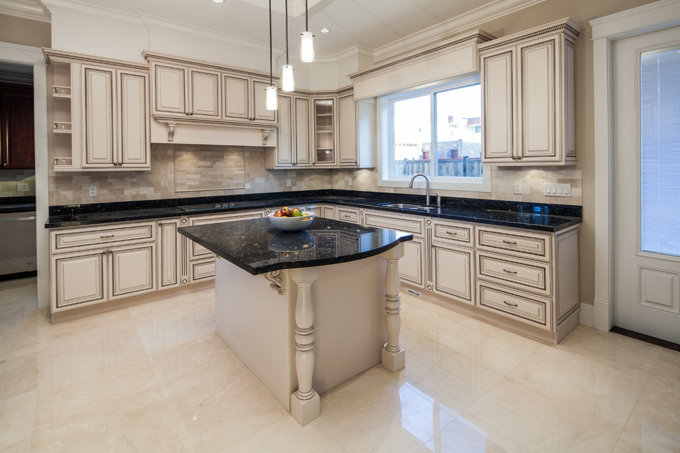 Foto di una cucina classica con lavello sottopiano, top in granito, paraspruzzi beige, elettrodomestici in acciaio inossidabile e pavimento in gres porcellanato