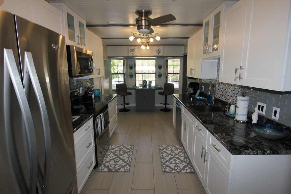 Mid-sized transitional galley porcelain tile and gray floor eat-in kitchen photo in Orlando with a single-bowl sink, shaker cabinets, white cabinets, granite countertops, gray backsplash, subway tile backsplash, stainless steel appliances and no island
