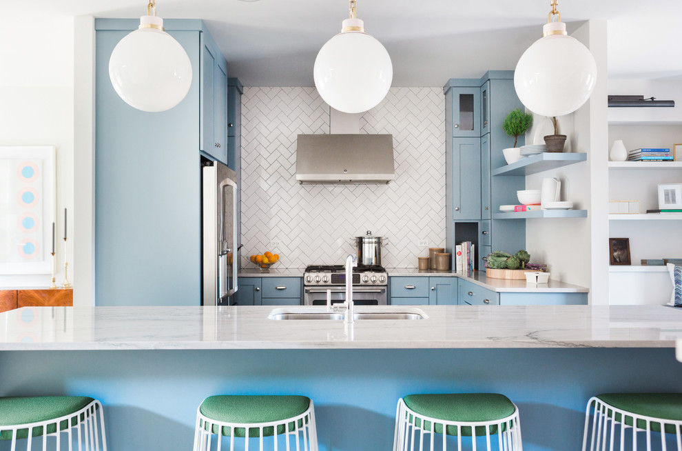 Klassische Küche in U-Form mit Unterbauwaschbecken, Schrankfronten im Shaker-Stil, blauen Schränken, Küchenrückwand in Weiß, Küchengeräten aus Edelstahl und Kücheninsel in Chicago