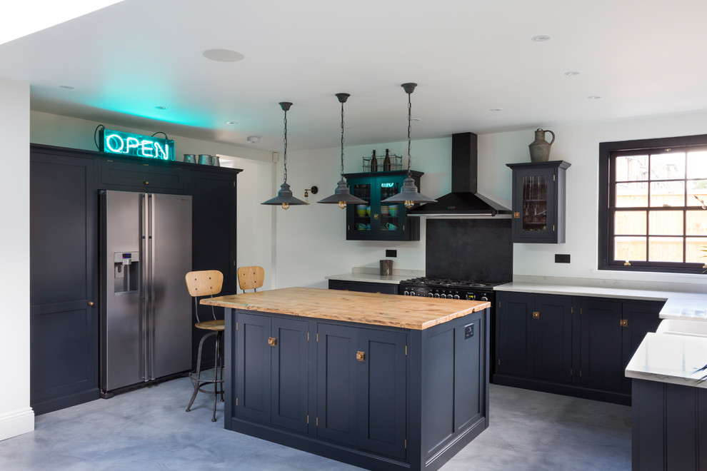 Exempel på ett mellanstort eklektiskt kök, med luckor med infälld panel, blå skåp, träbänkskiva, betonggolv, en köksö och grått golv