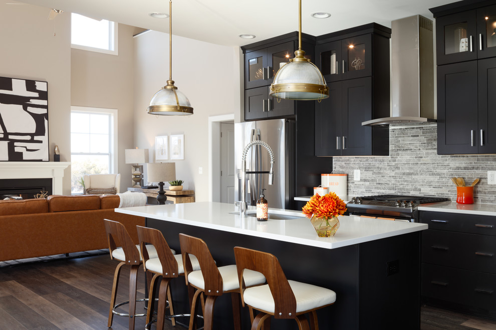 Bild på ett mellanstort vintage vit linjärt vitt kök och matrum, med en undermonterad diskho, skåp i shakerstil, svarta skåp, bänkskiva i kvarts, grått stänkskydd, stänkskydd i kalk, rostfria vitvaror, vinylgolv, en köksö och brunt golv