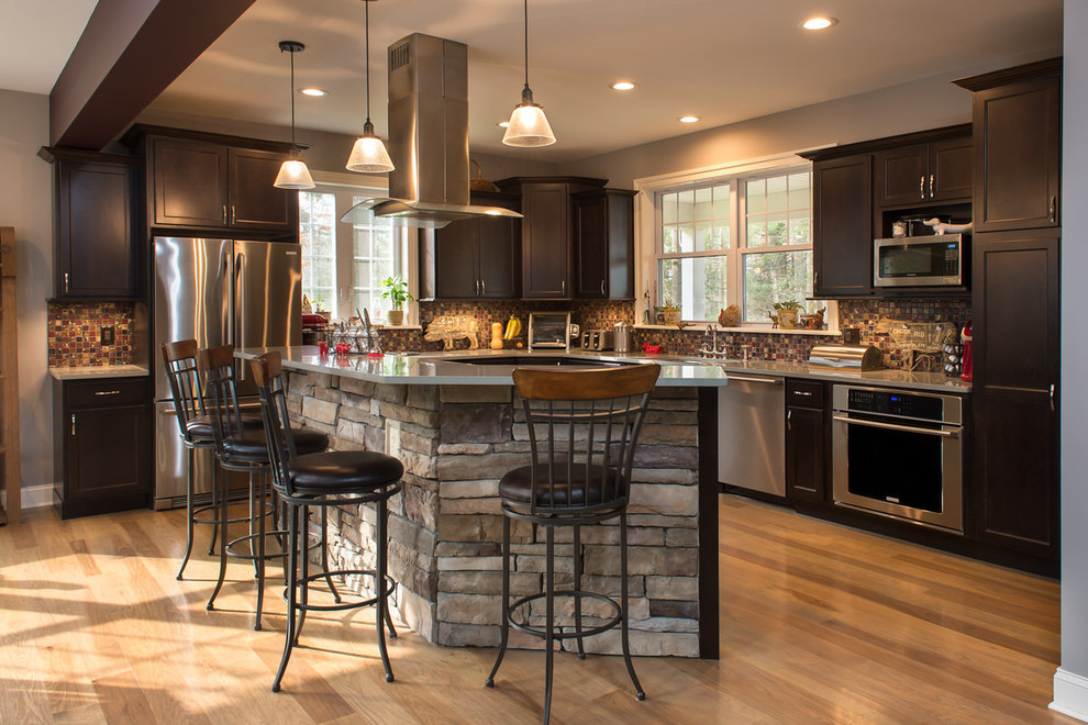 Bild på ett mellanstort amerikanskt kök, med skåp i shakerstil, skåp i mörkt trä, flerfärgad stänkskydd, en köksö, laminatbänkskiva, stänkskydd i mosaik, rostfria vitvaror, ljust trägolv och beiget golv