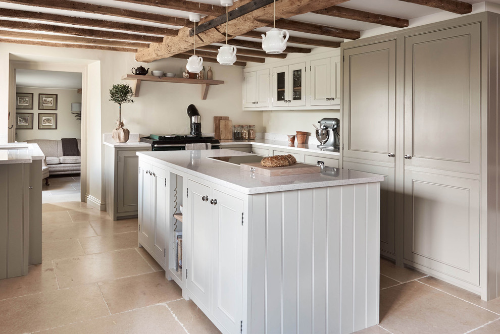 Foto på ett stort lantligt kök, med en undermonterad diskho, skåp i shakerstil, marmorbänkskiva, kalkstensgolv och en köksö
