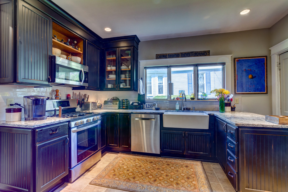 Example of a mid-sized 1960s ceramic tile and multicolored floor kitchen design in Other with a farmhouse sink, recessed-panel cabinets, distressed cabinets, granite countertops, gray backsplash, subway tile backsplash, stainless steel appliances and white countertops