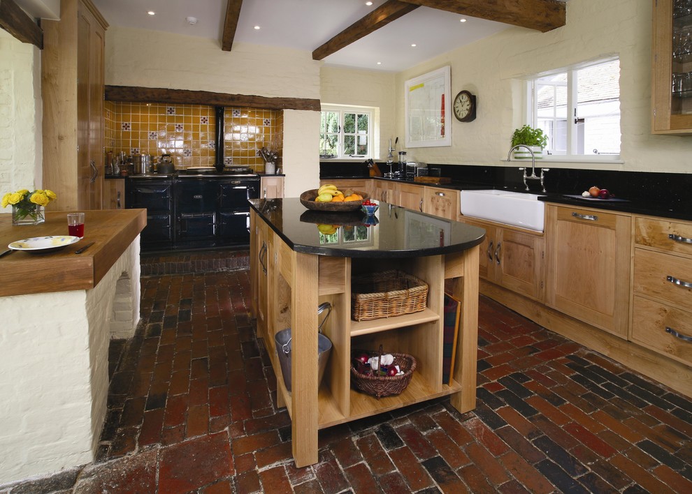 Large mountain style brick floor kitchen photo in Kent with a farmhouse sink, shaker cabinets, medium tone wood cabinets, granite countertops and an island