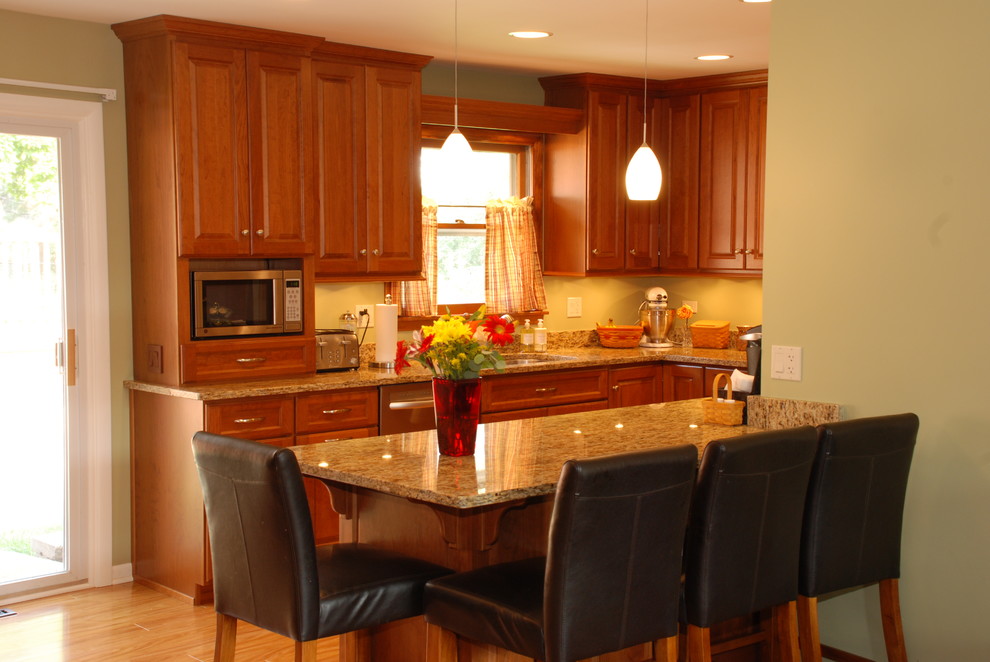 Mittelgroße Klassische Wohnküche mit hellbraunen Holzschränken, Granit-Arbeitsplatte, Küchengeräten aus Edelstahl, braunem Holzboden und Halbinsel in Chicago