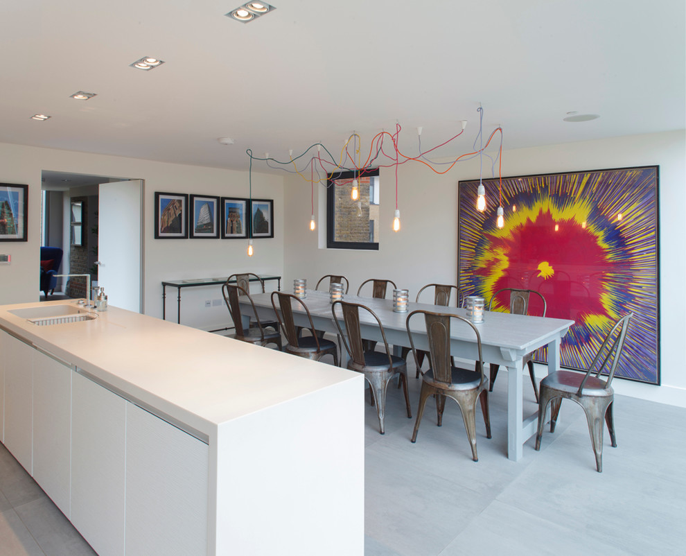 Eat-in kitchen - contemporary galley eat-in kitchen idea in London with an integrated sink, flat-panel cabinets, white cabinets and solid surface countertops